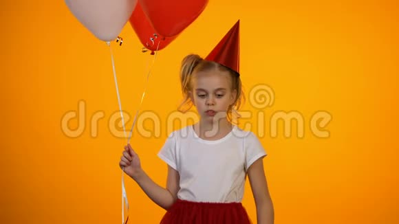 心烦意乱的女孩吹着派对喇叭拿着气球独自庆祝生日视频的预览图