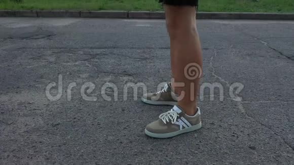 一个男人穿着棕色运动鞋在沥青上行走侧视视频的预览图