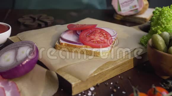 厨师在三明治里加入了切成片的泡菜火腿和蔬菜放在木板上做成了视频的预览图
