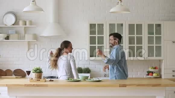年轻快乐活跃的一对夫妻在厨房里一起欢笑视频的预览图