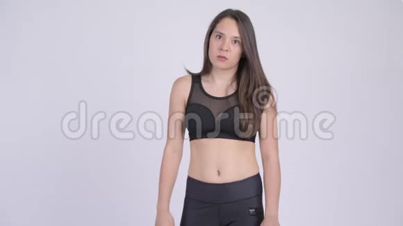年轻女子竖起大拇指失望地看着健身房视频的预览图