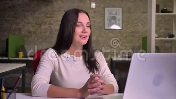 女商人在办公室里用笔记本电脑通过视频聊天视频的预览图