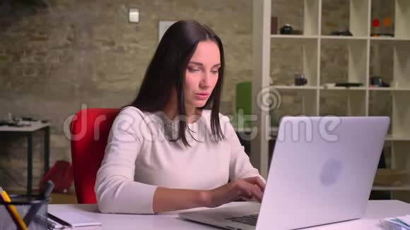 女商人在办公室的笔记本电脑前取得成功并靠在椅子上视频的预览图