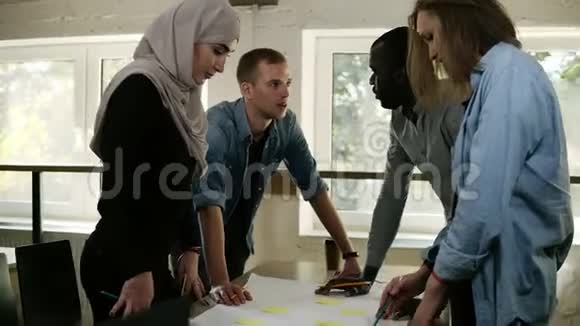 多元文化群体穆斯林妇女非洲男子和白种人男女在办公室讨论一个项目视频的预览图
