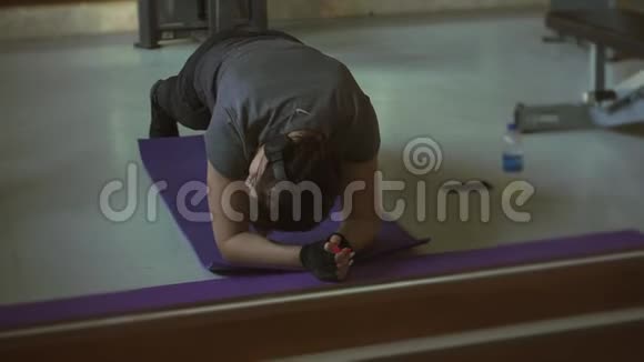 年轻的黑发女人在健身房锻炼木板视频的预览图