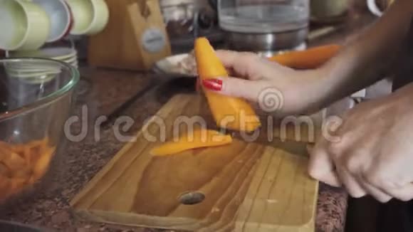 女人在木盘上用刀切胡萝卜视频的预览图