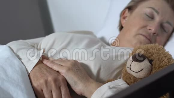 为与泰迪熊睡觉的高级妇女提供志愿服务并提供护理和支助视频的预览图