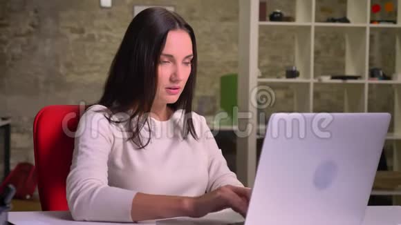 女人在笔记本电脑前的办公室里工作并同意点头视频的预览图