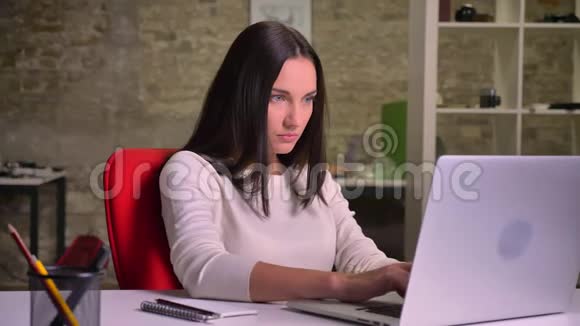 女人在笔记本电脑前的办公室工作在笔记本上做笔记视频的预览图