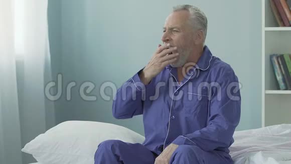 老人坐在床边打哈欠早晨快乐精力充沛视频的预览图