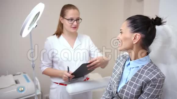 医学女医生在现代临床中针美容术前与女性客户交谈视频的预览图