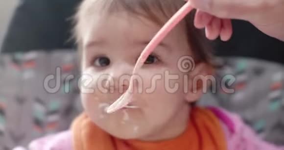 4K电影肖像一个10个月大的女婴被勺子喂养酸奶视频的预览图