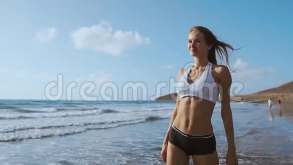 女孩走在海滩和水里视频的预览图