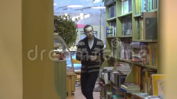 一个人走在书架之间这是书店或图书馆视频的预览图