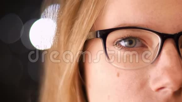 在金发白种人女子的眼镜中拍摄漂亮的半脸她轻松地站着看着镜头视频的预览图
