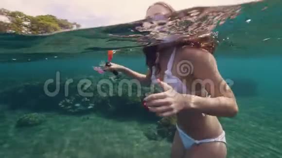 快乐的女人带着浮潜面具和管子微笑着在海水中游泳快乐的女人在海上游泳视频的预览图