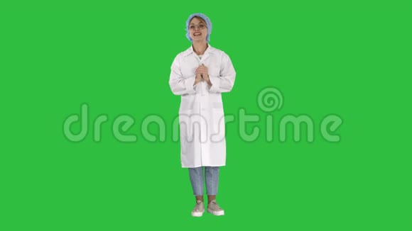 微笑可爱的医生女人与镜头在绿色屏幕上交谈色度键视频的预览图