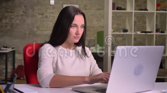 女商人在笔记本电脑前的办公室里靠在椅子上有一种恼怒和烦恼的感觉视频的预览图
