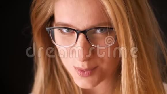 金发白种人戴眼镜的女孩的近景害羞的脸看上去很自然地看着镜头很可爱地遮住了自己视频的预览图