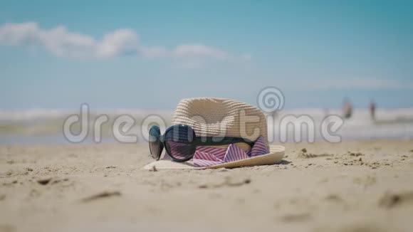 沙滩上戴草帽和太阳镜的暑假概念带帽子和眼镜的海滩背景假日视频的预览图