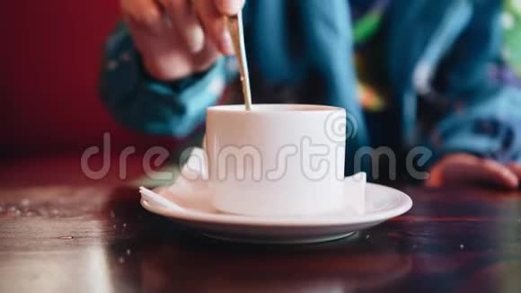 一个在咖啡馆里的男孩在一杯茶里搅拌糖快关门拍得不错视频的预览图