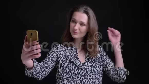 年轻漂亮的白种人女性的特写照片她带着自拍在电话里微笑着在前面摆弄她的头发视频的预览图