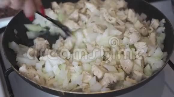 切碎的洋葱和鸡块混合在锅里视频的预览图