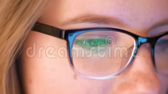 近距离拍摄白种人的女人正看着屏幕上反射的眼镜IT专家聪明的现代人视频的预览图