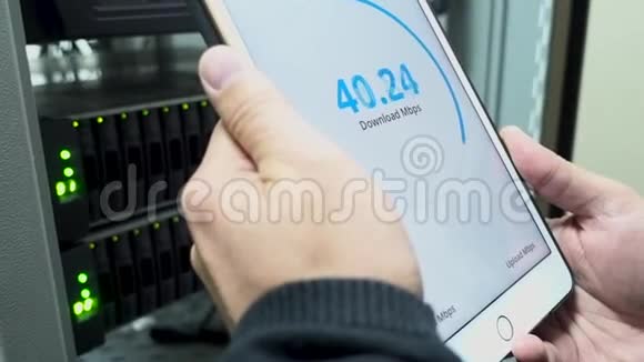 信息技术工程师测量网络速度手里拿着一台平板电脑LED指示的背景的背景视频的预览图
