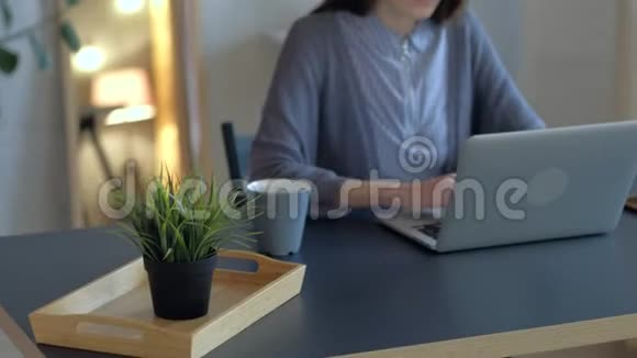 戴眼镜的漂亮女人在办公室里用笔记本电脑工作中等射击视频的预览图