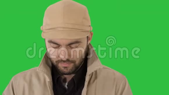 壕沟里的一个男人的脸在绿色屏幕上看着他的智能手机铬钥匙视频的预览图