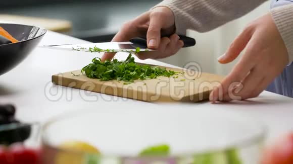 女人在蔬菜沙拉中加入切碎的欧芹视频的预览图