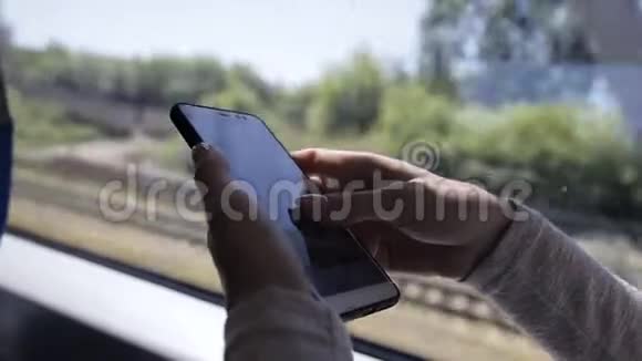 一位年轻女士在火车上使用智能手机的特写视频的预览图