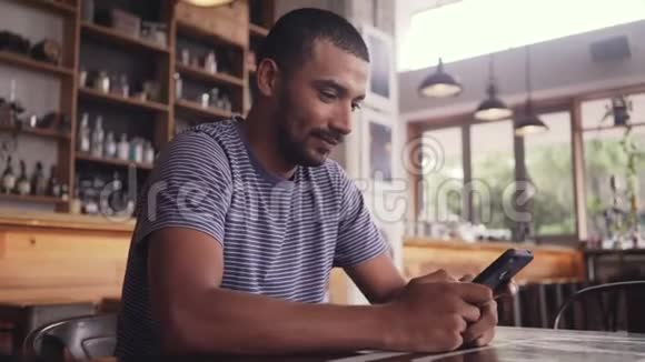 一个年轻人坐在咖啡馆里用手机发短信视频的预览图