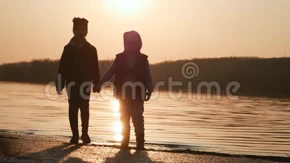 哥哥和姐姐在日落时在河边玩视频的预览图