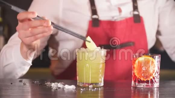 酒保用长镊子用橘皮调味片整理鸡尾酒视频的预览图