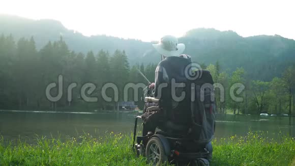在森林和山地附近的美丽湖泊中残疾渔民乘坐电动轮椅捕鱼的4K分辨率视频的预览图