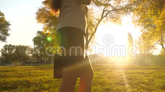 穿裙子的女人手里拿着一个公文包被明亮的阳光照亮商务女性的美腿走路视频的预览图