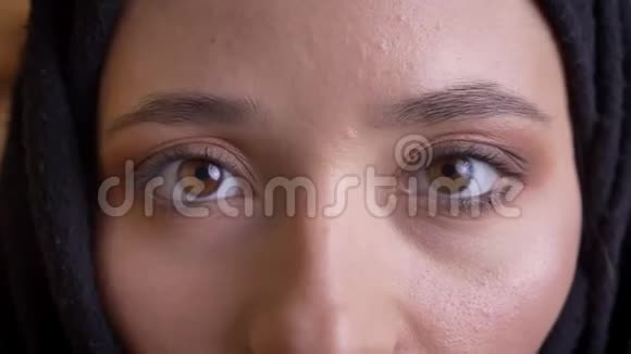 年轻美丽的穆斯林女性脸上戴着黑色头巾的特写镜头眼睛直勾勾地盯着镜头视频的预览图
