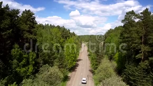 绿色森林之间灰色毁坏道路上的车辆行驶视频的预览图