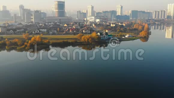 无人机接近美丽的日出城市建筑全景在明斯克白俄罗斯附近静湖水边映天视频的预览图