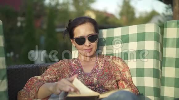 亚洲女人在外面看书在智能手机上聊天视频的预览图