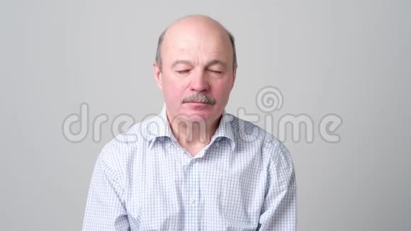 欧洲老秃头男人感到疲倦和困倦视频的预览图