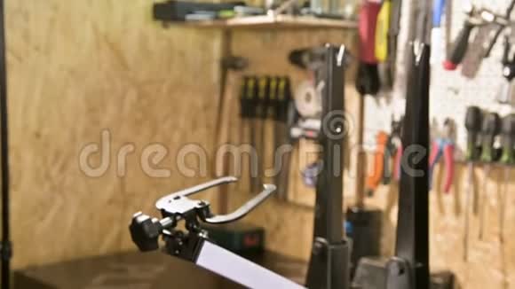 年轻的男自行车修理工在车间的一个支架上用专门的扳手拧紧车轮的辐条视频的预览图