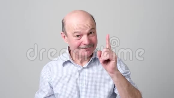 微笑的老人伸出食指给出建议视频的预览图