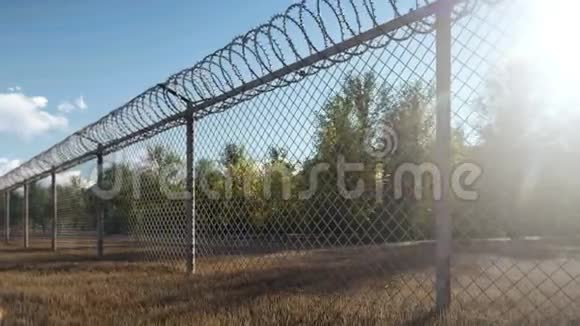 阳光阳光和秋天的树木通过金属栅栏和铁丝网可以看到视频的预览图
