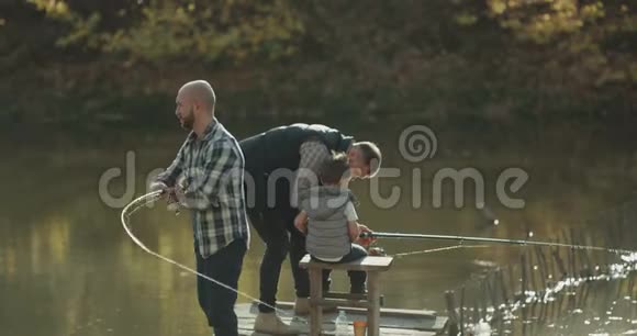 特写渔人在桥上钓鱼爸爸鼓励儿子钓鱼视频的预览图