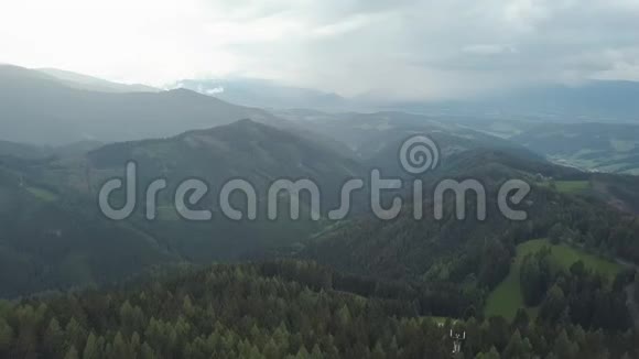 照相机飞过高山上惊人的松林穿过云层向后移动视频的预览图
