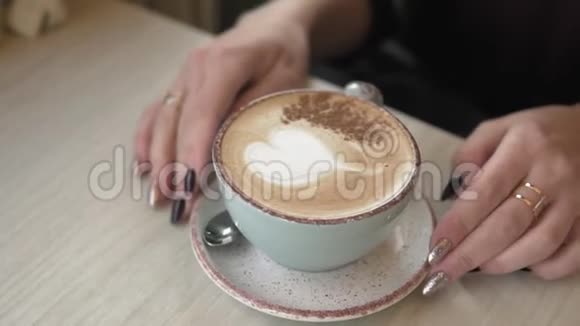 女孩的双手特写喝咖啡在有复印空间的咖啡馆里放松视频的预览图
