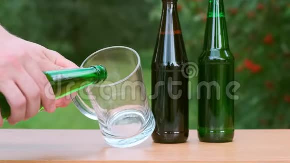 把啤酒从桌子上的瓶子里倒入玻璃杯里外斗别紧张视频的预览图
